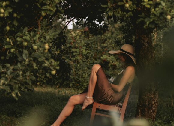 A woman sitting in a chair under a tree