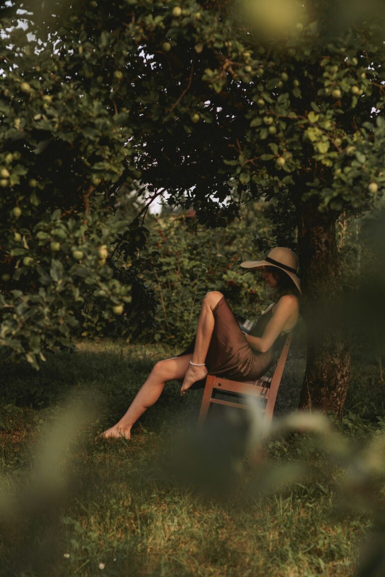 A woman sitting in a chair under a tree
